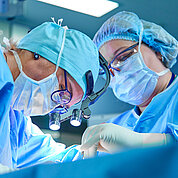 A surgeon's team in uniform performs an operation on a patient at a cardiac surgery clinic. Modern medicine, a professional team of surgeons, health