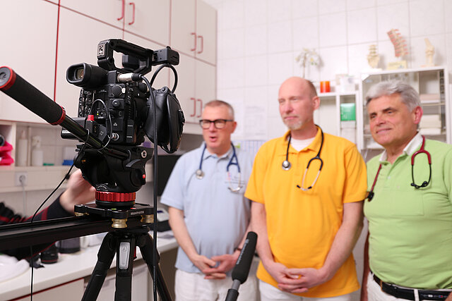 Die drei Ärzte vor einer Videokamera in der Arztptraxis